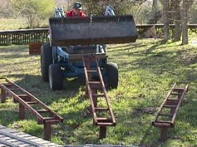 David Hannah III uses the front-end loader to lift one of the steaming bays at the Isomville turntable