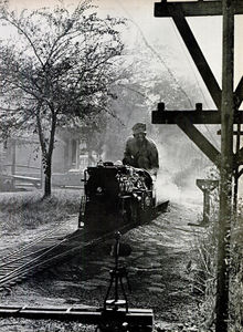 Mann chugs down backyard tracks which extend thousands of feet and were installed at cost of $4.50 a foot. Engine is 16 feet long, weighs just under two tons and has steam pistons that develop 150 horsepower, more than that of many cars. Special tender car is capable of carrying 15 gallons of water, 40 gallons of diesel fuel (Ed: Rebuilder Vance Nickerson said this information is incorrect, that the water capacity has always been more than the oil capacity. As of 2019 the tender has two stainless steel tanks).