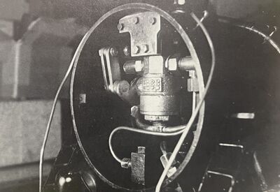 The throttle is shown three-quarters open. Attachment to the smokebox is by the use of a brass block, secured to the top of the throttle by 6-32 screws. The steel plate is attached to the mounting angle (riveted to the top of the smokebox) by the use of 5-40 screws. The mounting angle and location were part of the mounting to fasten the original throttle.