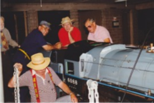 Dick Bartel, Dick Thomas, and Bill Norred discuss the backhead arrangement of the 15 inch gauge Hudson at The Goleta Valley Western Railroad. Ed Lebec is in the foreground. Photo by Rick Zobelein.