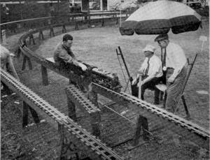 An interesting picutre of part of the track of the New England Live Steamers, at Danvers, Mass., U.S.A. Mr. Poor driving his 3-1/2 inch gauge 4-6-2 locomotive through the South transfer switch. The provision of cover for the pointmen will be noted! The point-operating mechanism is clearly descernible in the picture.