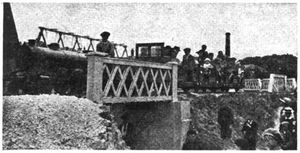 Engine and train passing over bridge on Margate Miniature Line that spans a roadway.